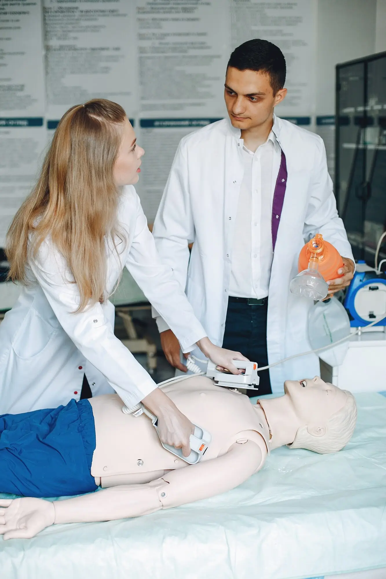 Medical students practicing defibrillator use on a simulation mannequin.